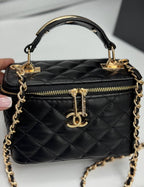 Chanel black quilted synthetic leather vanity crossbody bag with gold chain strap and CC logo.