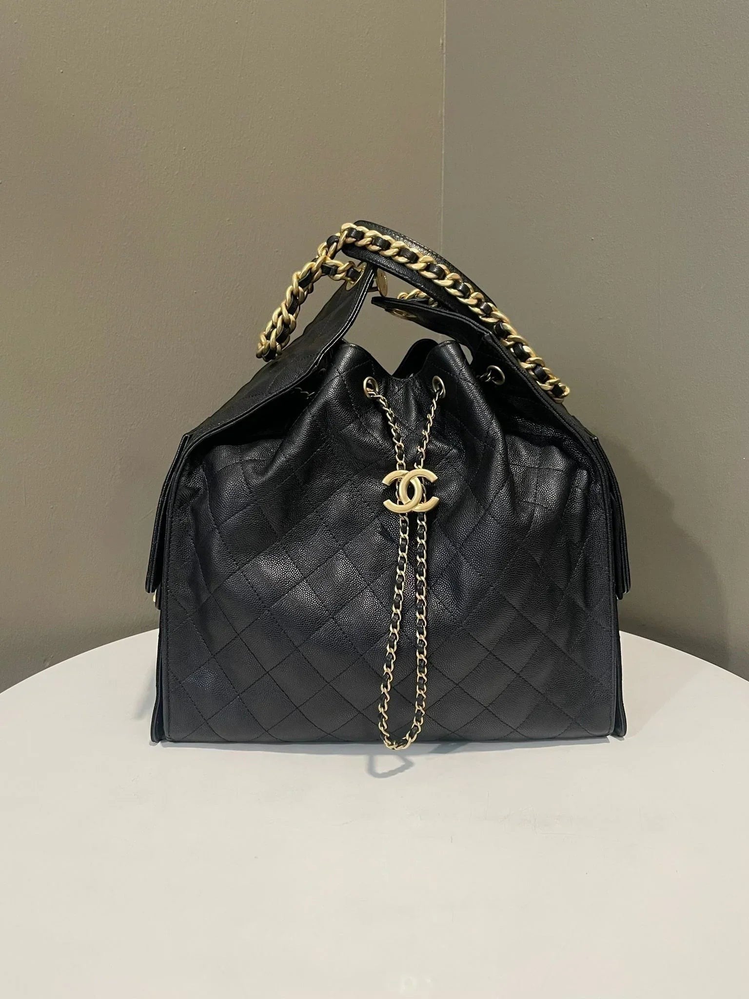 Divabags black grained calfskin Chanel 25 drawstring bag with gold chain strap and CC logo detail.
